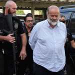 Joao Vaccari, treasurer of Brazil's ruling Workers' Party, is escorted by police as he arrives to a legal medical institute in Curitiba