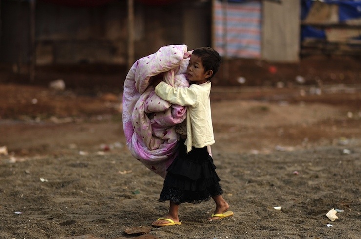 A girl holds a quilt at a refugee camp at Myanmar's border town with China, in Kokang