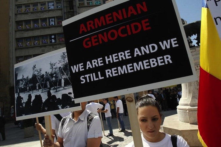 Members of Armenian community in Romania hold banners during a rally marking the anniversary of mass killings of Armenians in Ottoman Empire in 1915, in downtown Bucharest