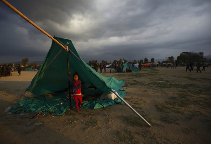 A child stands inside a makeshift shelter in an open ground to keep safe after an earthquake in Kathmandu, Nepal April 26, 2015. Saturday's 7.9 magnitude earthquake killed more than 2,400 people and devastated Kathmandu valley.  REUTERS/Navesh Chitraka      TPX IMAGES OF THE DAY