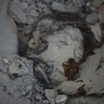 The body of a woman lies trapped in the debris of a collapsed house after an earthquake in Kathmandu