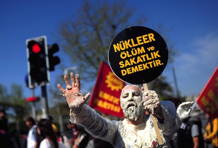 A demonstrator holds a placard during a protest against the Turkish government's plans to build a nuclear power plant in the country, at Kadikoy square in Istanbul April 26, 2015. Construction of Turkey's first nuclear power plant is expected to start at the end of 2016, Energy Minister Taner Yildiz said, around 18 months later than originally planned. The placard reads, "Nuclear means death and disability" REUTERS/Yagiz Karahan