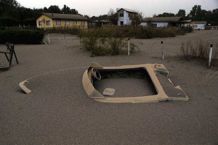 A boat is seen in a house backyard at Ensenada town which is covered with ash from Calbuco volcano