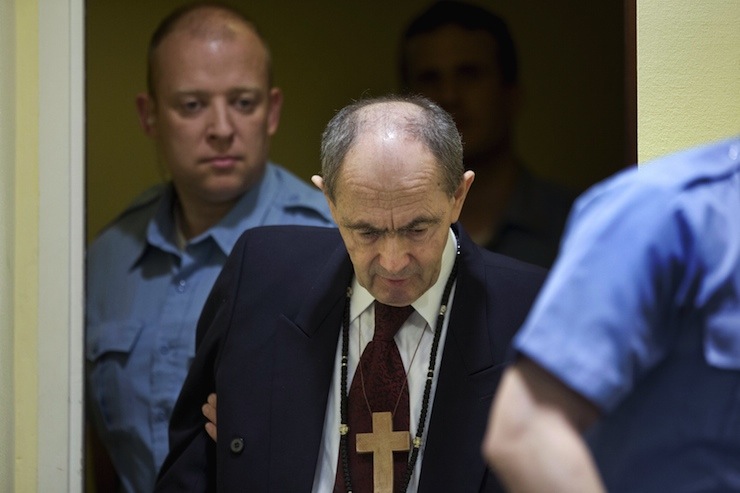 Tolimir is escorted by U.N. security guards as he arrives in the courtroom of the the Yugoslav war crimes tribunal who delivered its judgment in his appeal case in The Hague