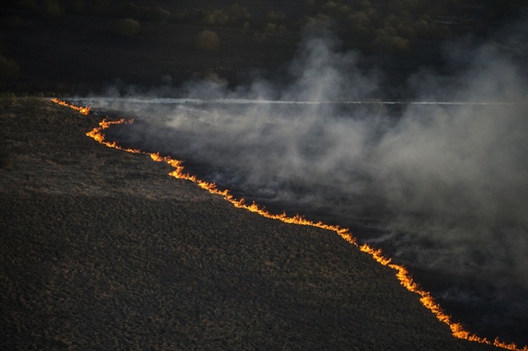 An aerial view from a helicopter shows fire on the ground in northern Ukraine