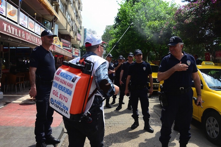 MITINGE ISPARTA'DAN KATILAN BIR KISI, UZERINDE 'HUKUMETIN BIBER GAZINA KARSI TURK MEMURUNUN GUL SUYU' YAZILI ZIRAI ILACLAMA BIDONUNDAKI GUL SUYUNU POLISLERE SIKTI. FOTO: YUSUF BASTUG / ADANA, (DHA)
