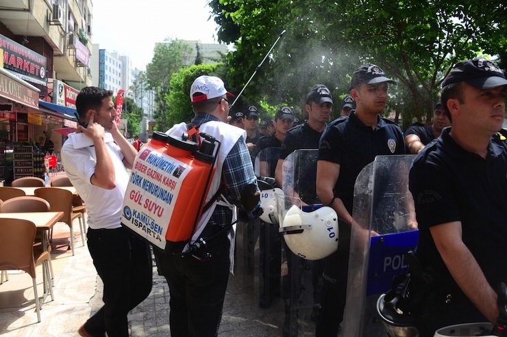 MITINGE ISPARTA'DAN KATILAN BIR KISI, UZERINDE 'HUKUMETIN BIBER GAZINA KARSI TURK MEMURUNUN GUL SUYU' YAZILI ZIRAI ILACLAMA BIDONUNDAKI GUL SUYUNU POLISLERE SIKTI. FOTO: YUSUF BASTUG / ADANA, (DHA)