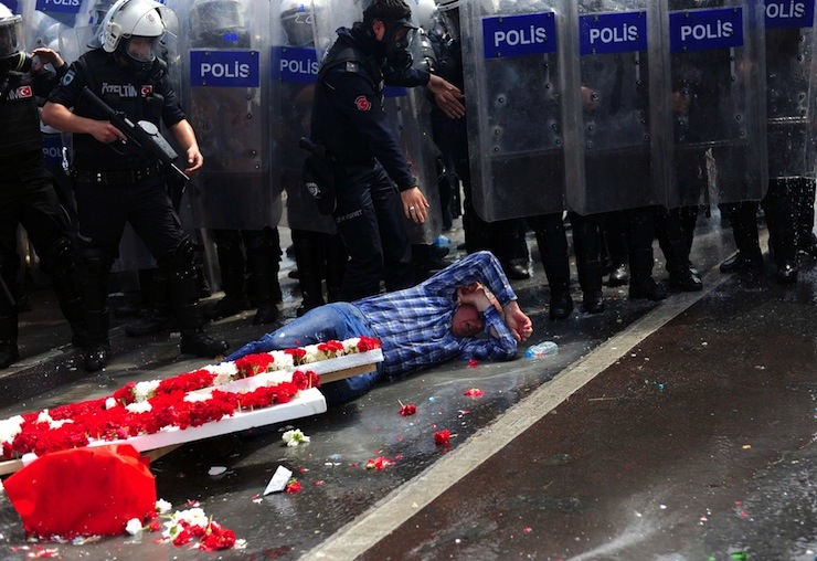 A protester lies in front of policemen during clashes with police in Besiktas neighbourhood of Istanbul