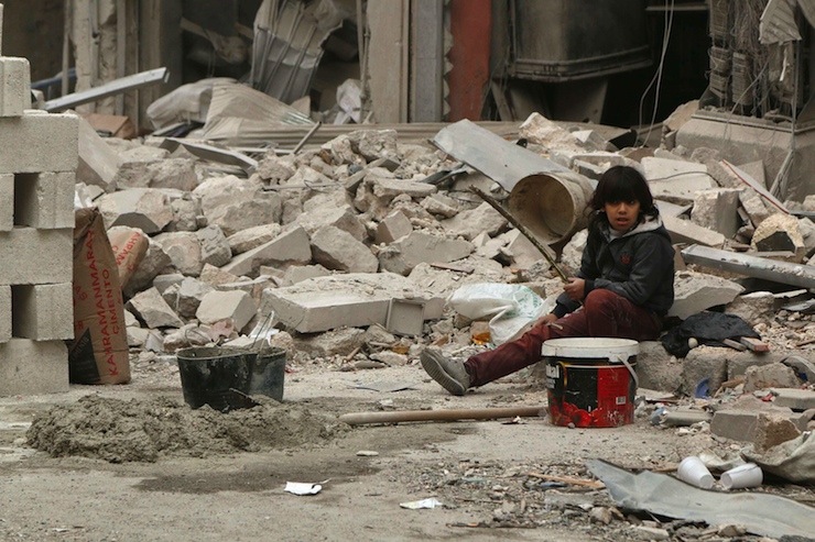 A boy sits on the rubble of buildings damaged from what activists said was shelling by forces loyal to Syria's President Bashar al-Assad, in Kalasa neighbourhood, Aleppo November 13, 2014.REUTERS/Hosam Katan (SYRIA - Tags: POLITICS CIVIL UNREST MILITARY)