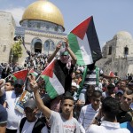 Palestinians wave flags during a protest to mark Nakba day in Jerusalem's Old City