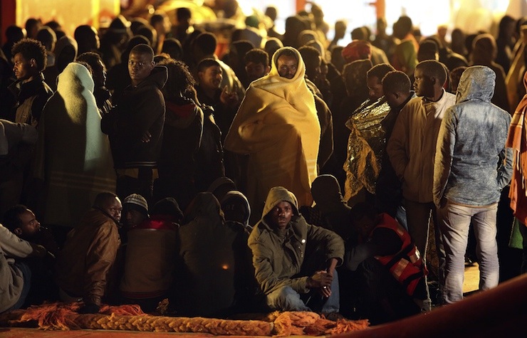 Migrants rest after disembark from tug boat Asso29 in the Sicilian harbour of Pozzallo
