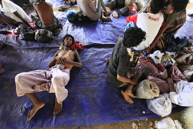 Rohingya refugees sit on a plastic sheet at Matang Raya village, Baktya district in Aceh Utara, Aceh province, Indonesia