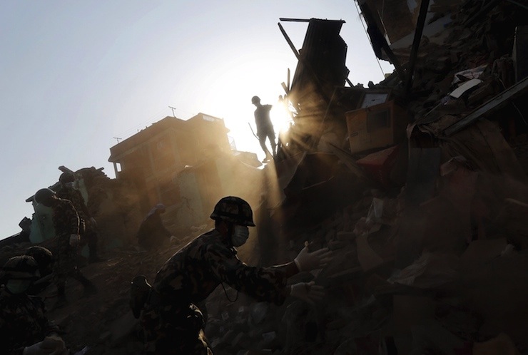 Nepal army personnel and earthquake survivors search for belongings at a collapsed house in Sankhu on the outskirts of Kathmandu