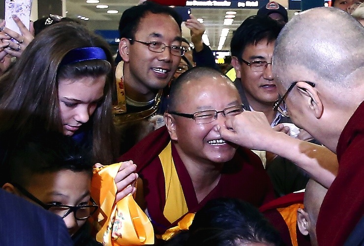 Exiled Tibetan spiritual leader the Dalai Lama pinches the nose of a supporter after arriving at Sydney International airport