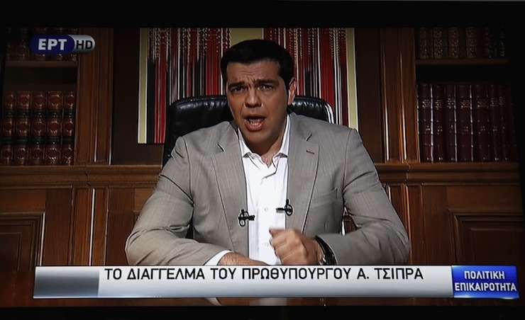 Greek Prime Minister Alexis Tsipras is seen on a television monitor while addressing the nation in Athens, Greece