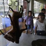A customer chooses dog meat at a dog meat restaurant ahead of local dog meat festival in Yulin