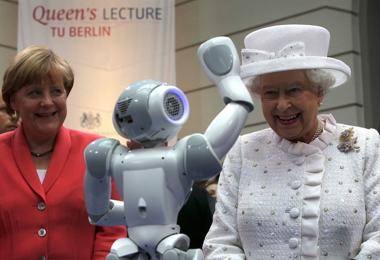 German Chancellor Angela Merkel and Britain's Queen Elizabeth smile as a robot waves during their visit at the Technical University of Berlin