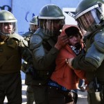 A protester is detained by riot policemen during a demonstration to demand changes in the education system, in Santiago