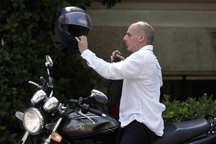 Greek Finance Minister Varoufakis removes his helmet after arriving on his motorbike for a governmental council at the PM's Tsipras office in Maximos mansion in Athens