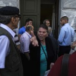 People, most of them pensioners, argue among themselves outside a closed National Bank branch at the bank's headquarters in Athens