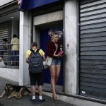 People line up to withdraw cash from an ATM outside a Eurobank branch in Athens