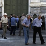 People, most of them pensioners, line up outside a closed National Bank branch at the bank's headquarters in Athens