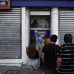 File photo of a man reacting as people line up to withdraw cash from an ATM outside a Eurobank branch in Athens