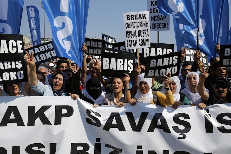 Demonstrators shout slogans against ruling AK Party as they hold banners during protests against Monday's bomb attack in Suruc, in Istanbul, Turkey