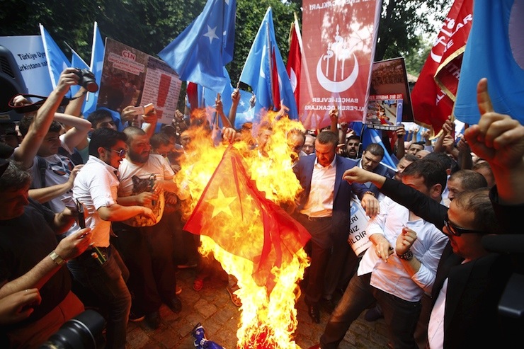 Demonstrators set fire to a Chinese flag during a protest against China near the Chinese Consulate in Istanbul