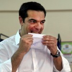 Greek Prime Minister Alexis Tsipras licks ballot envelope before voting in national referendum at a polling station in Athens