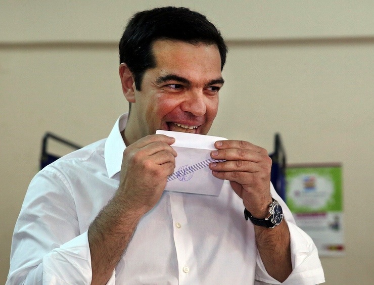 Greek Prime Minister Alexis Tsipras licks ballot envelope before voting in national referendum at a polling station in Athens