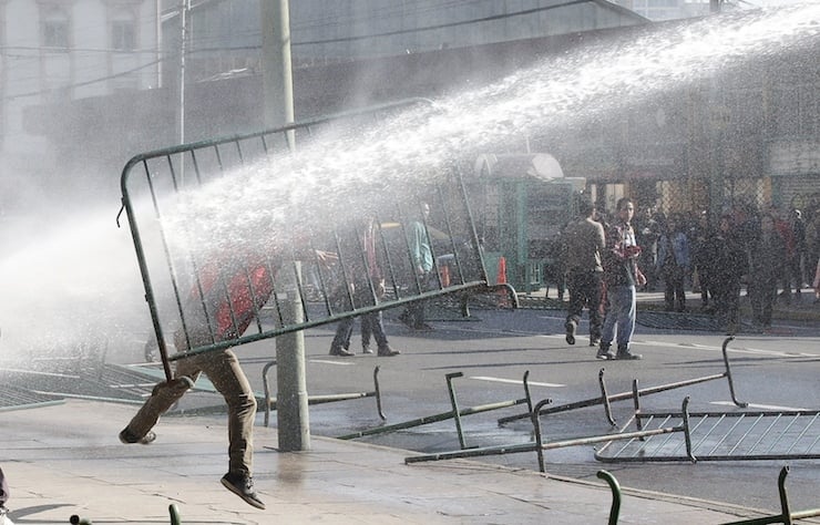 A student is hit by water cannon from a riot truck during a rally against the goverment to demand changes and new reforms in the education system in front of the national congress in Valparaiso, July 23, 2015. REUTERS/Rodrigo Garrido  TPX IMAGES OF THE DAY