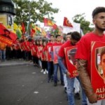 Members of the Kurdish community in France hold posters depicting victims of Monday's bomb attack in Suruc, Turkey, during a demonstration to condemn the attack, in Paris