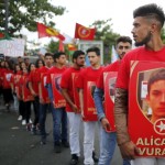 Members of the Kurdish community in France hold posters depicting victims of Monday's bomb attack in Suruc, Turkey, during a demonstration to condemn the attack, in Paris