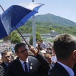 A stone is thrown at Serbia's Prime Minister Vucic as bodyguards use umbrella to protect him during unrest at a ceremony marking the 20th anniversary of the Srebrenica massacre in Potocari