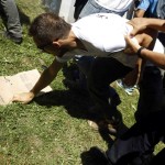 A protester is held by a policeman during unrest at a ceremony marking the 20th anniversary of the Srebrenica massacre in Potocari, near Srebenica