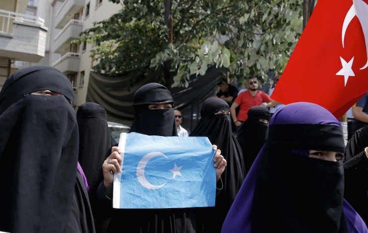 Women hold flags as they attend a protest in front of the Thai Embassy in Ankara