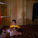 An Uighur refugee boy does his homework where he is housed in a gated complex in the central city of Kayseri, Turkey