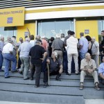 People wait to enter a Piraeus Bank branch at the city of Iraklio in the island of Crete