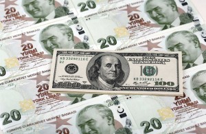 A file photo illustration taken on January 7, 2014 in Istanbul shows a 100 U.S. dollar banknote against 20 Turkish lira banknotes. Turkey's lira touched a new record low against the dollar on January 23, 2014, after the central bank left interest rates on hold and failed to meet market expectations for earlier and longer additional tightening.  REUTERS/Murad Sezer/Files (TURKEY - Tags: BUSINESS POLITICS)