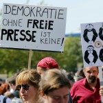 Demonstrators hold up placards during a rally to protest against a criminal complaint by the domestic intelligence agency, the Office for the Protection of the Constitution in Berlin