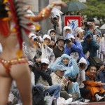 People take photos of a samba dancer during the 34th annual Asakusa Samba Carnival in Tokyo