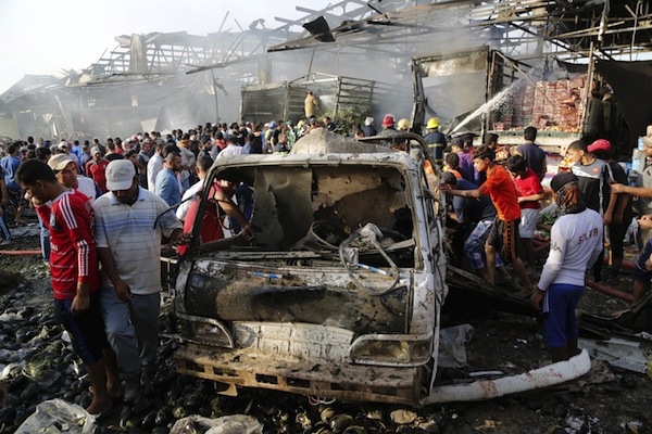 Residents gather at the site of a truck bomb attack at a crowded market in Baghdad ,August 13,2015.  At least 60 people were killed and 200 wounded on Thursday when a refrigerated truck packed with explosives blew up in a crowded market in Sadr City, a Shi'ite district in northeastern Baghdad, police and medical sources said. REUTERS/Wissm Al- Okili  NO ARCHIVES      TPX IMAGES OF THE DAY