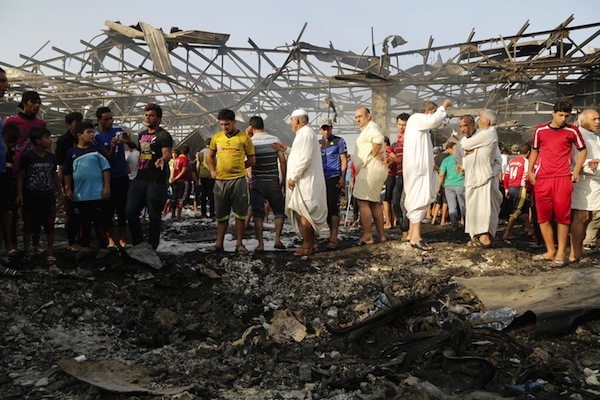 Residents gather at the site of a truck bomb attack at a crowded market in Baghdad ,August 13,2015.  At least 60 people were killed and 200 wounded on Thursday when a refrigerated truck packed with explosives blew up in a crowded market in Sadr City, a Shi'ite district in northeastern Baghdad, police and medical sources said. REUTERS/Wissm Al- Okili  NO ARCHIVES