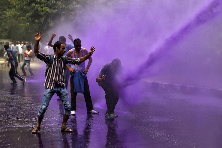 Government employees are hit by dyed water from a water cannon used by Indian police to disperse protesters during a demonstration in Srinagar, August 10, 2015. Indian police on Monday detained dozens of protesting government employees in Srinagar who were demanding their long pending arrears and a regularisation of temporary jobs, according to protesters. REUTERS/Danish Ismail      TPX IMAGES OF THE DAY