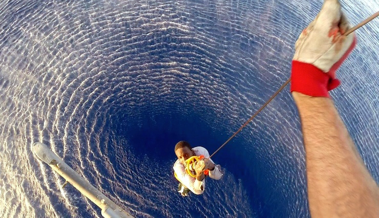 A migrant is rescued by an Italian Navy helicopter in the area where his boat sank in the Mediterranean Sea in this August 11, 2015 handout courtesy of the Italian Navy. Up to 50 migrants went missing after a large rubber dinghy sank in the Mediterranean Sea, Italian rescuers said on Wednesday, while more than 1,500 were picked up from other vessels in the past 24 hours.  REUTERS/Italian Navy/Handout via ReutersATTENTION EDITORS - THIS PICTURE WAS PROVIDED BY A THIRD PARTY. REUTERS IS UNABLE TO INDEPENDENTLY VERIFY THE AUTHENTICITY, CONTENT, LOCATION OR DATE OF THIS IMAGE. FOR EDITORIAL USE ONLY. NOT FOR SALE FOR MARKETING OR ADVERTISING CAMPAIGNS. THIS PICTURE IS DISTRIBUTED EXACTLY AS RECEIVED BY REUTERS, AS A SERVICE TO CLIENTS.      TPX IMAGES OF THE DAY