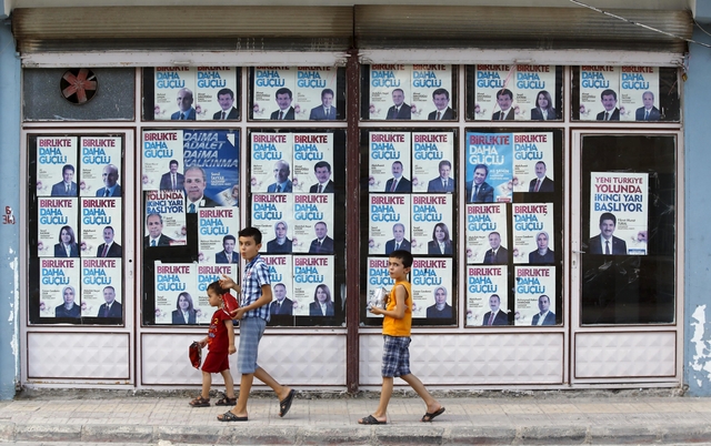 Boys walk past by local headquarters of the ruling AK Party in Karkamis
