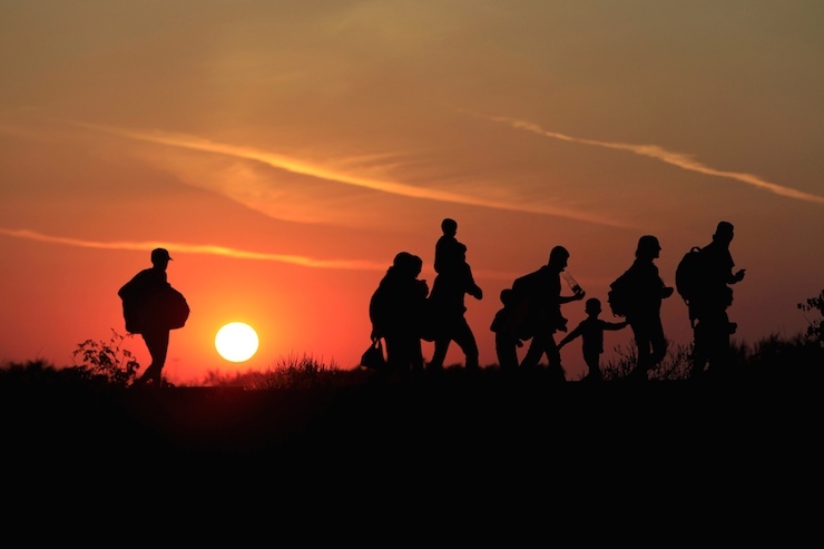 Migrants walk along in the sunset after crossing into Hungary from the border with Serbia near Roszke, Hungary, August 30, 2015. About 100,000 migrants, many of them from Syria and other conflict zones in the Middle East, have taken the Balkan route into Europe this year, heading via Serbia for Hungary and Europe's Schengen zone of passport-free travel. REUTERS/Bernadett Szabo TPX IMAGES OF THE DAY