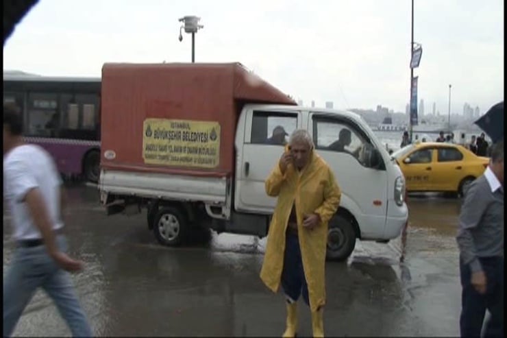 USKUDAR'DA ANIDEN BASTIRAN YAGMUR, YAYA VE TASIT TRAFIGINI OLUMSUZ ETKILEDI. TASITLAR YOLDA ILERLEMEKTE ZORLUK CEKERKEN, VATANDASLAR AYAKKABILARINI CIKARTARAK YOLU ASTI. (FOTO: UGUR AYAZSIN/ISTANBUL, DHA)