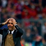 Bayern Munich's coach Guardiola reacts after his team scored a goal during their German first division Bundesliga soccer match against Wolfsburg in Munich